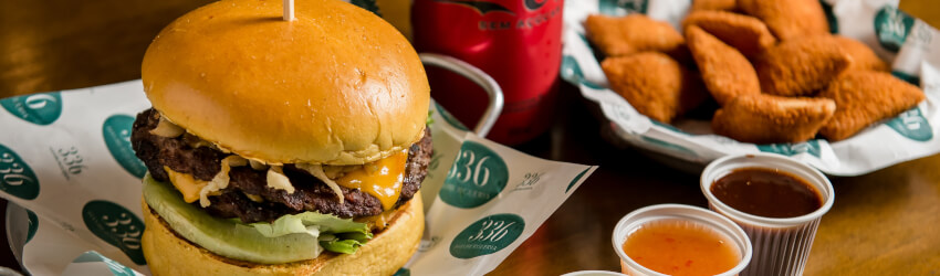 Burger artesanal da 336 no papel de embrulho da casa, com frango empanado e molhos